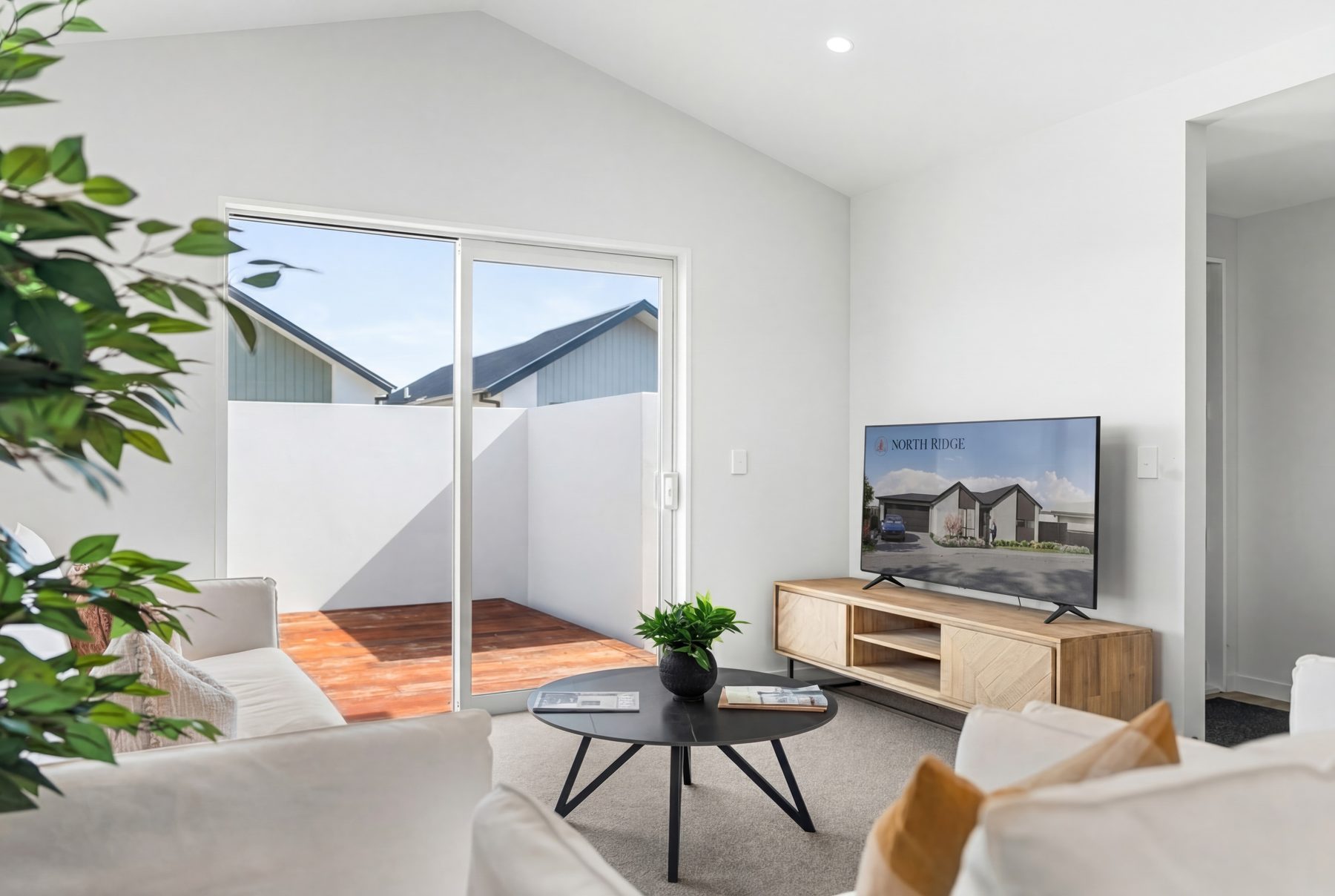 Light-filled living room with pitched ceiling opening to the deck