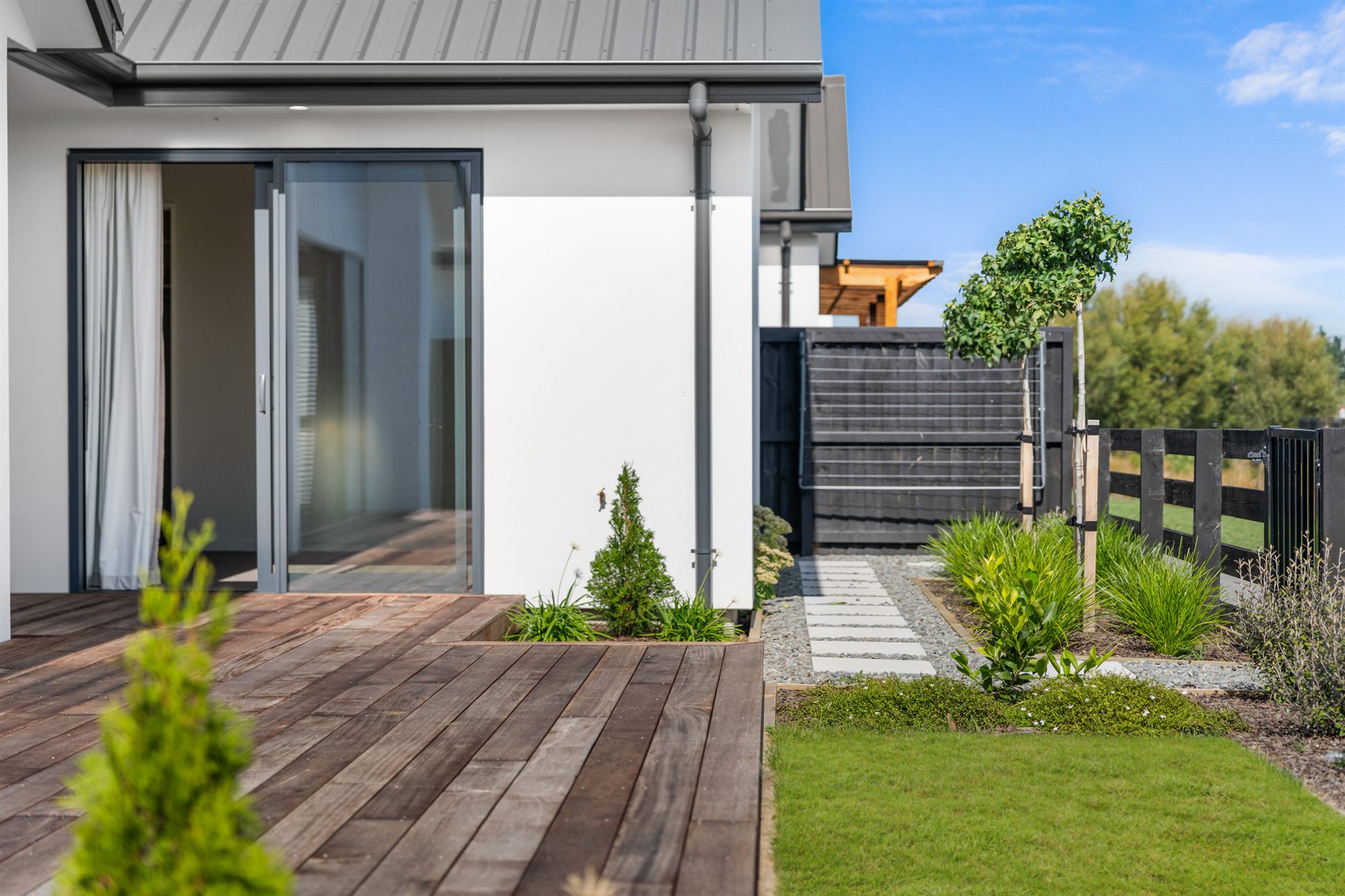 Timber deck, sliding doors and landscaped garden at an Elmbridge Mews home — seamless indoor-outdoor living on its own freehold title