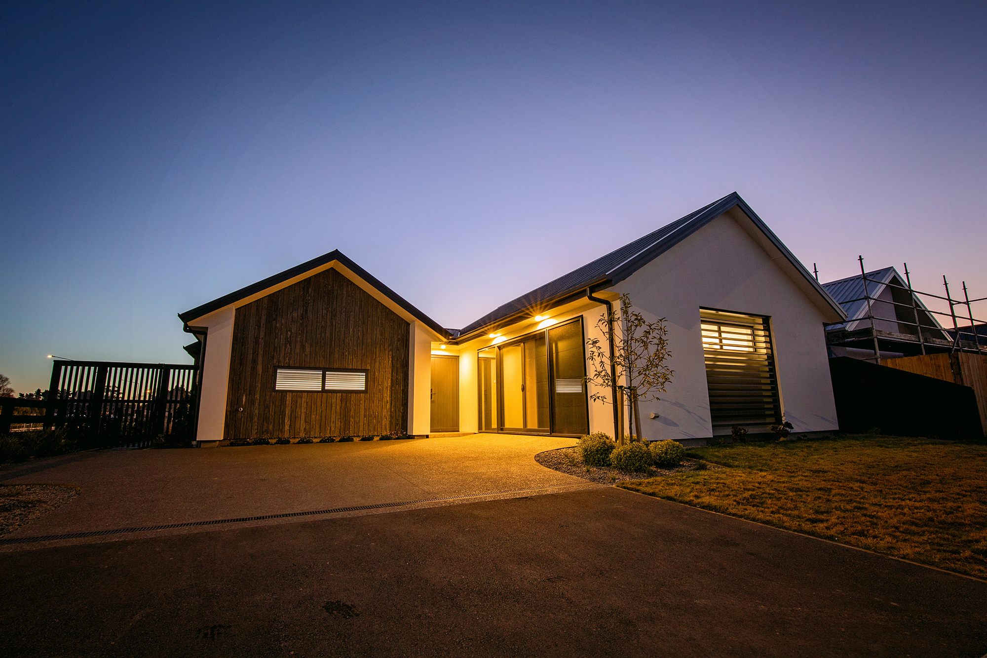 An Elmbridge Mews home at dusk — gabled rooflines along Waianiwa Place