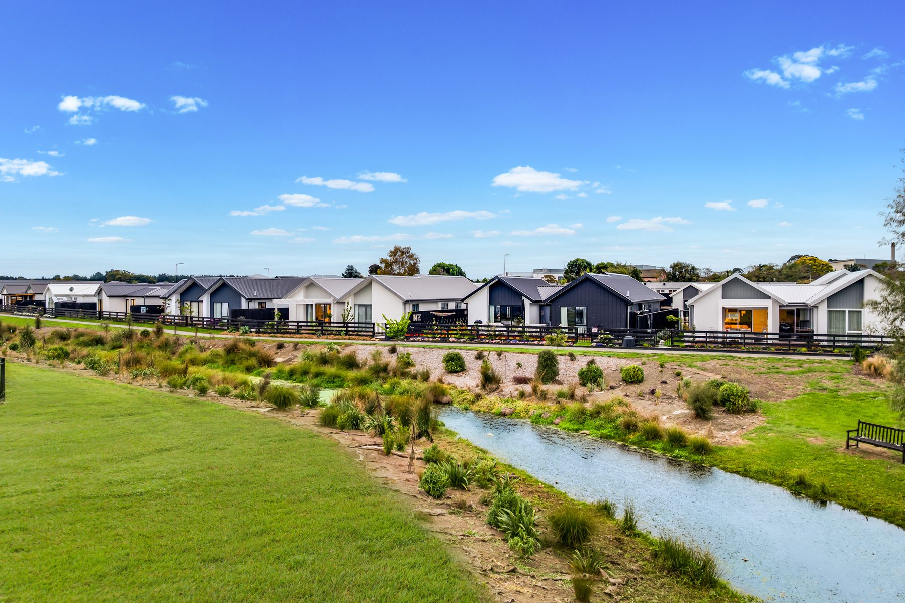 Elmbridge Mews homes along the planted stream — a finished, established community